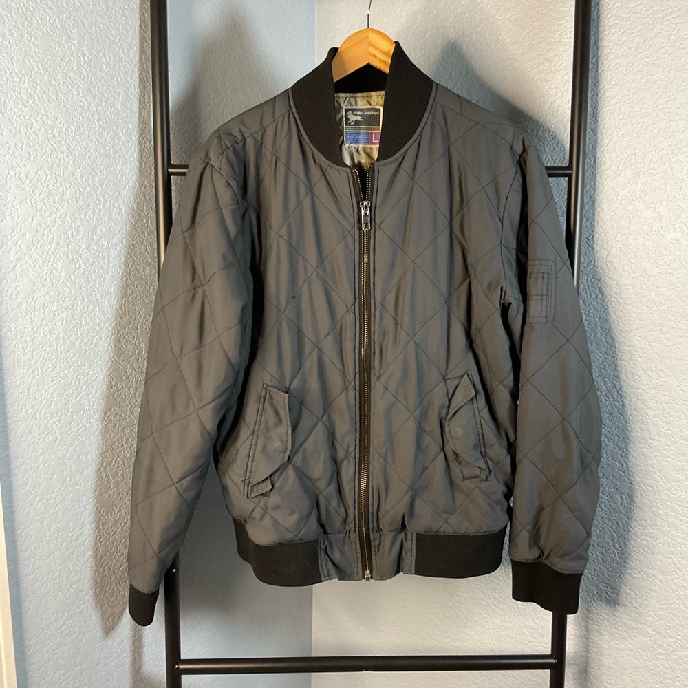 Grey quilted bomber jacket. Has some damage in the under arm size men's large